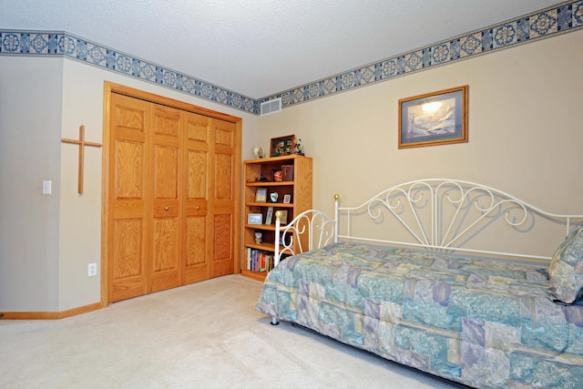 carpeted bedroom with a textured ceiling and a closet