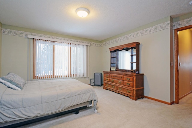 bedroom featuring multiple windows, light colored carpet, and a textured ceiling