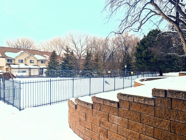 snow covered pool featuring fence