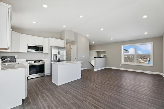 kitchen with a kitchen island, white cabinetry, sink, dark hardwood / wood-style flooring, and stainless steel appliances