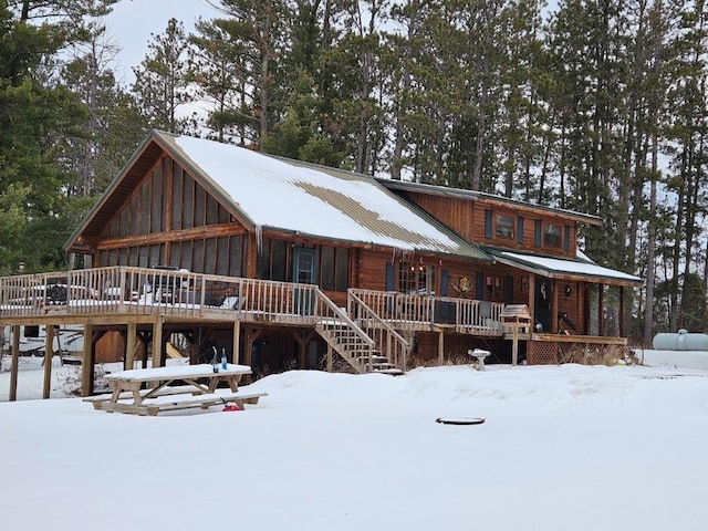 log cabin with a wooden deck and covered porch