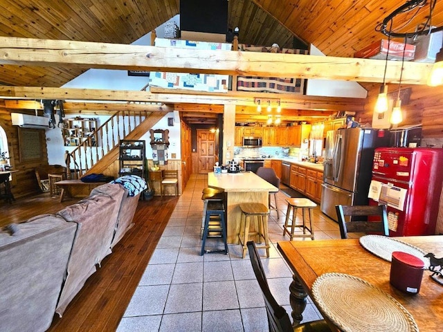 dining room featuring sink, dark tile patterned floors, wooden walls, high vaulted ceiling, and wooden ceiling