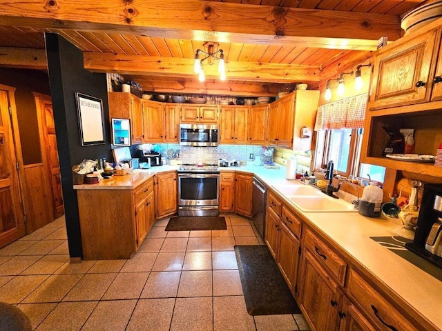 kitchen with decorative light fixtures, sink, stainless steel appliances, wooden ceiling, and beam ceiling