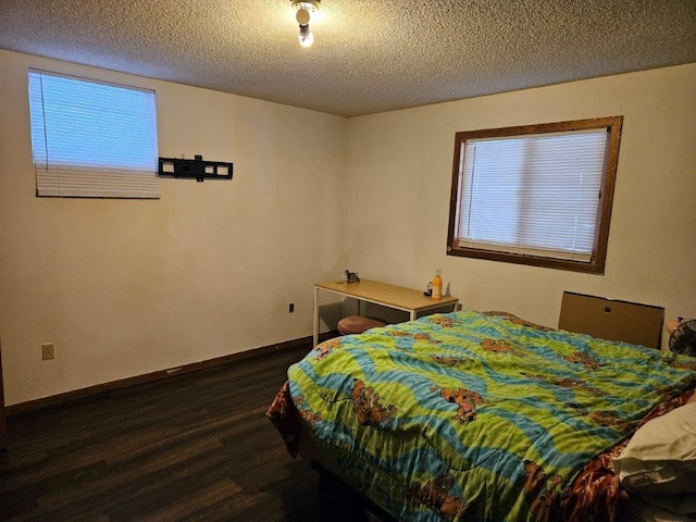 bedroom with dark hardwood / wood-style floors and a textured ceiling