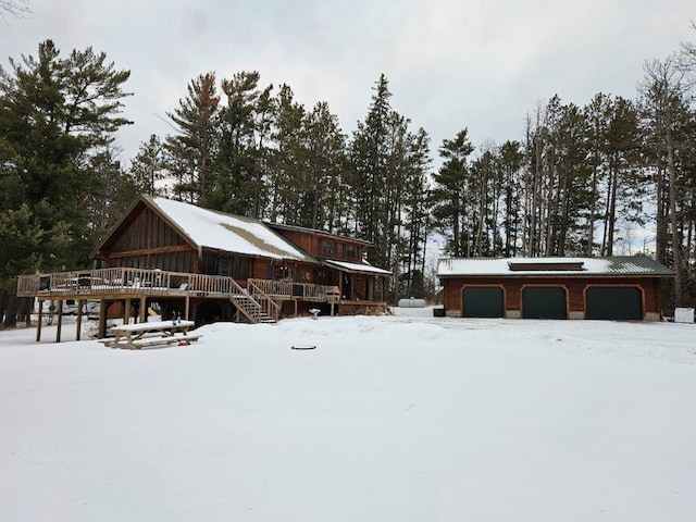 yard layered in snow with a garage and a wooden deck