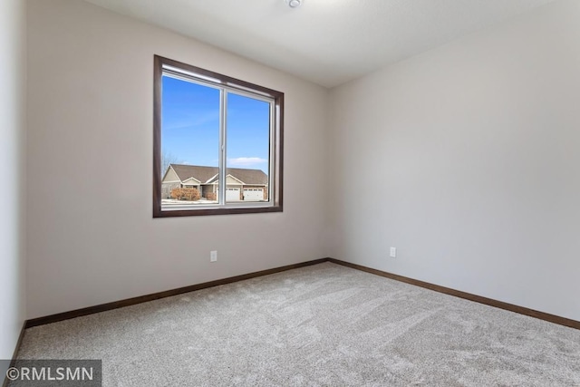carpeted empty room with baseboards