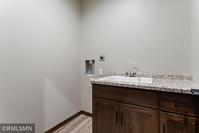 bathroom featuring vanity, wood finished floors, and baseboards