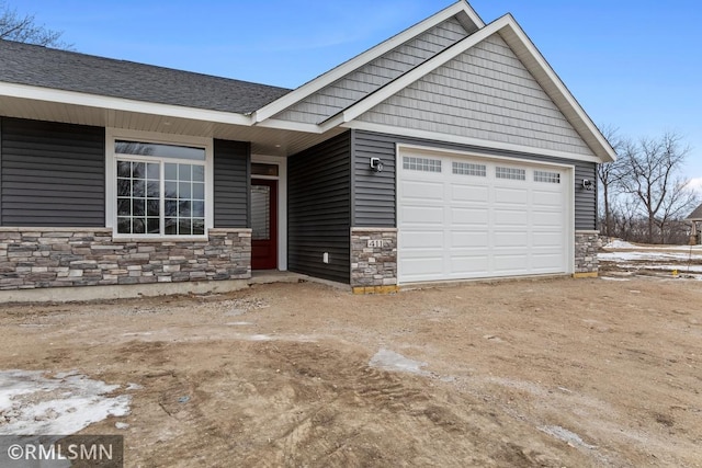 view of front of property with a garage and stone siding