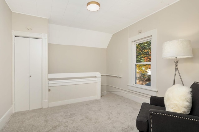 living area with lofted ceiling and light colored carpet