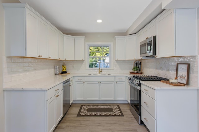 kitchen featuring sink, stainless steel appliances, white cabinets, and light wood-type flooring