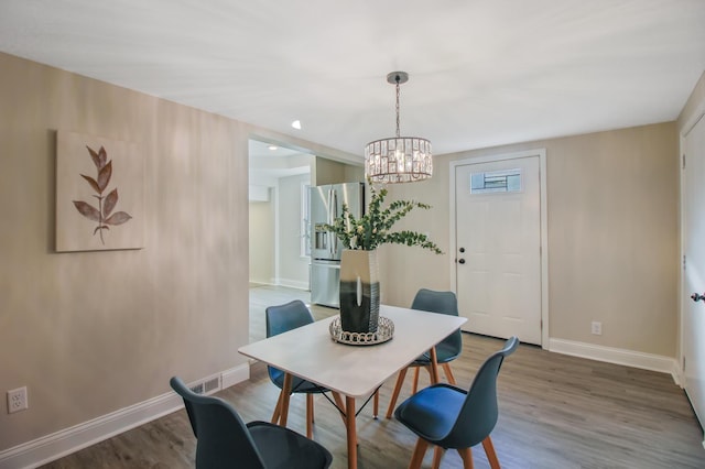 dining space featuring a notable chandelier and wood-type flooring