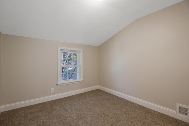 carpeted spare room with lofted ceiling