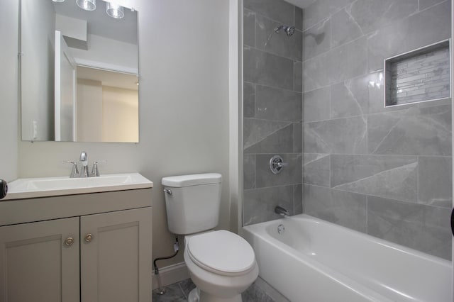 full bathroom featuring vanity, tiled shower / bath, and toilet