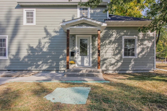 doorway to property featuring a lawn