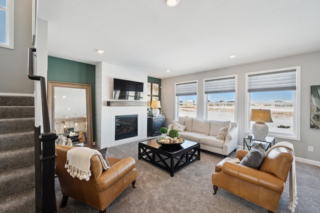 living room with a large fireplace and light colored carpet