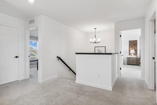 hall featuring a notable chandelier and light colored carpet