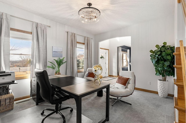 office featuring visible vents, baseboards, arched walkways, a notable chandelier, and carpet flooring