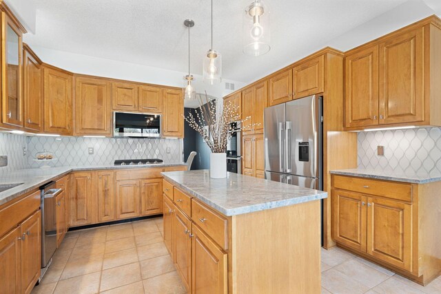 kitchen featuring light stone counters, stainless steel appliances, hanging light fixtures, glass insert cabinets, and a center island