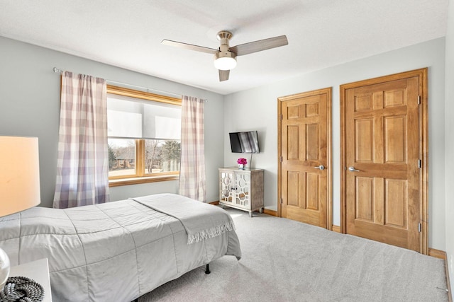 carpeted bedroom featuring a ceiling fan and baseboards