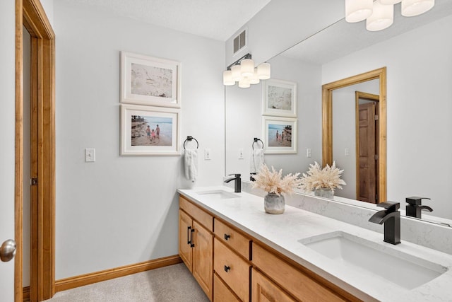 bathroom featuring a sink, visible vents, baseboards, and double vanity