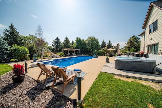 pool with a patio area, a hot tub, a water slide, and a pergola