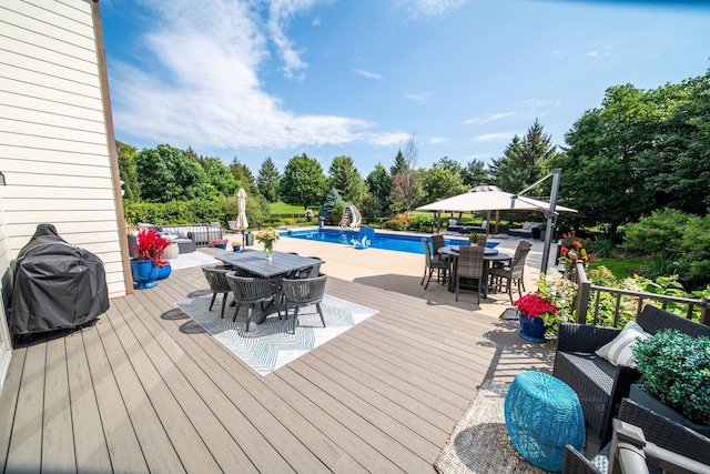 wooden deck with outdoor dining space and an outdoor pool