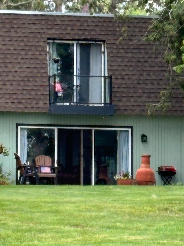 rear view of property featuring a lawn