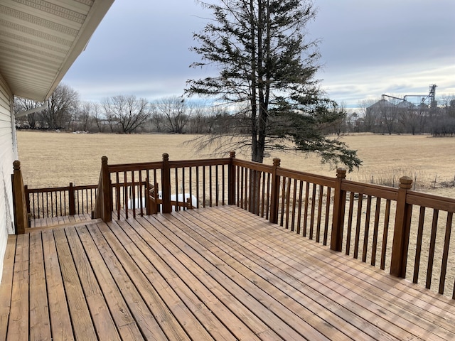 wooden deck with a rural view and a lawn