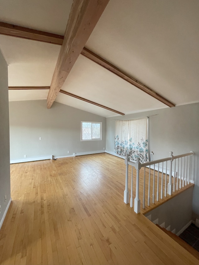 additional living space with light hardwood / wood-style flooring and vaulted ceiling with beams