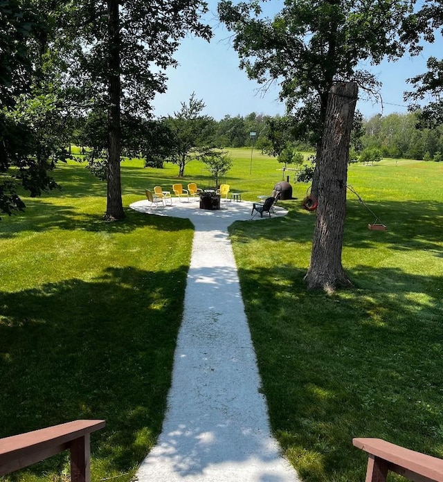 view of home's community with a patio, a yard, and an outdoor fire pit