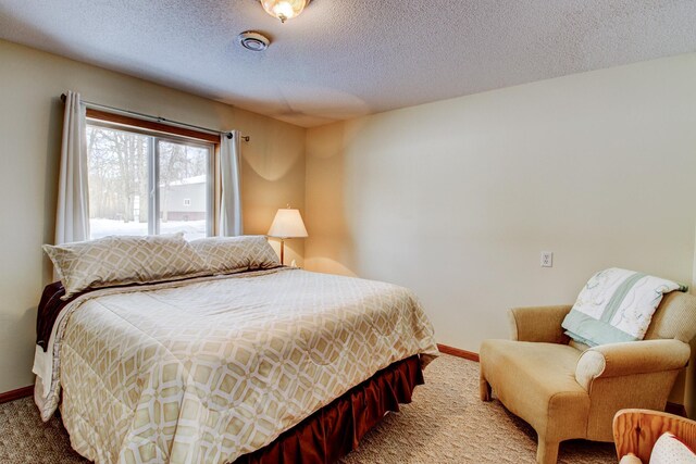 bedroom with baseboards, carpet, and a textured ceiling
