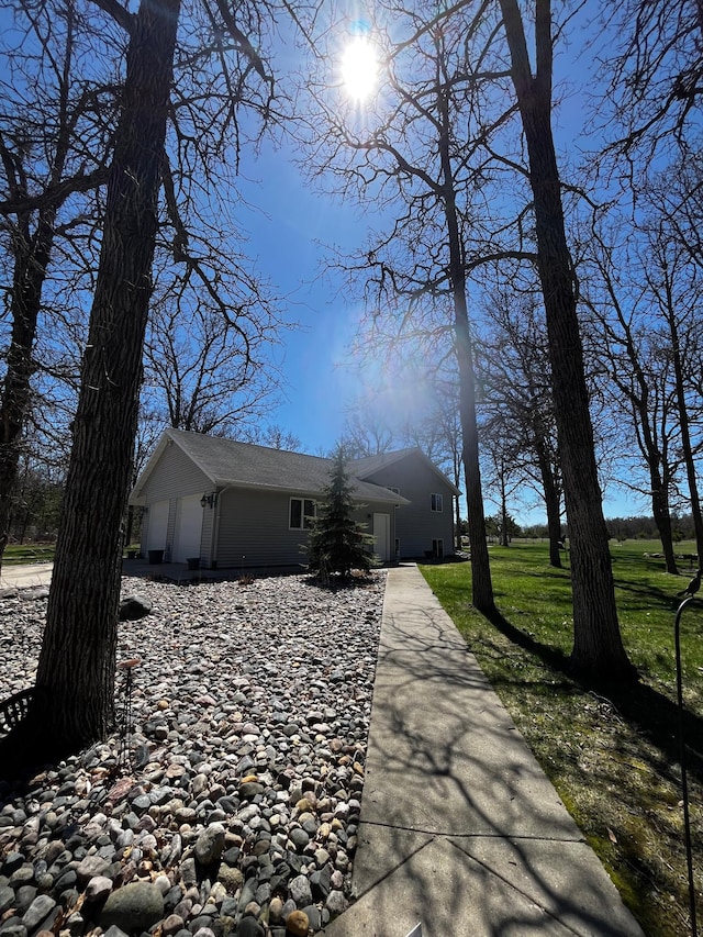 view of side of home featuring a garage and a yard