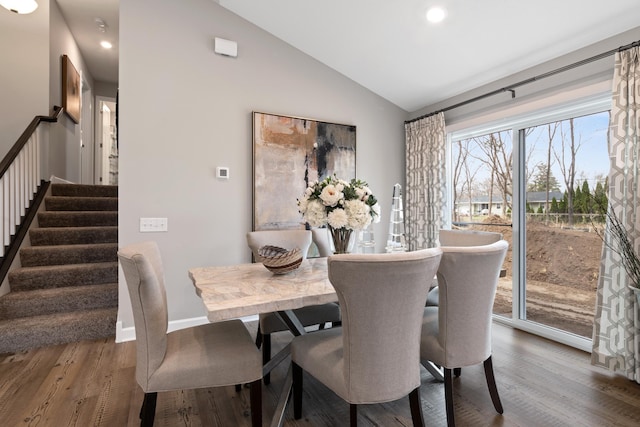 dining room with vaulted ceiling and hardwood / wood-style floors