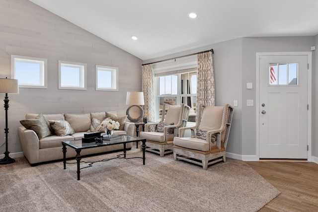 living room featuring lofted ceiling, a healthy amount of sunlight, and light hardwood / wood-style floors