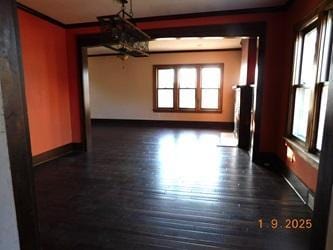 unfurnished dining area featuring crown molding and dark hardwood / wood-style floors