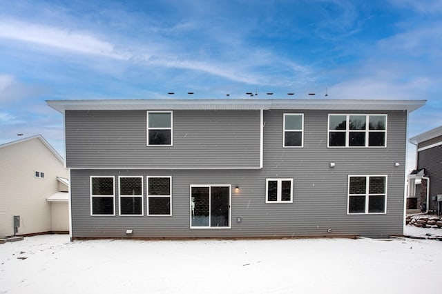 view of snow covered back of property