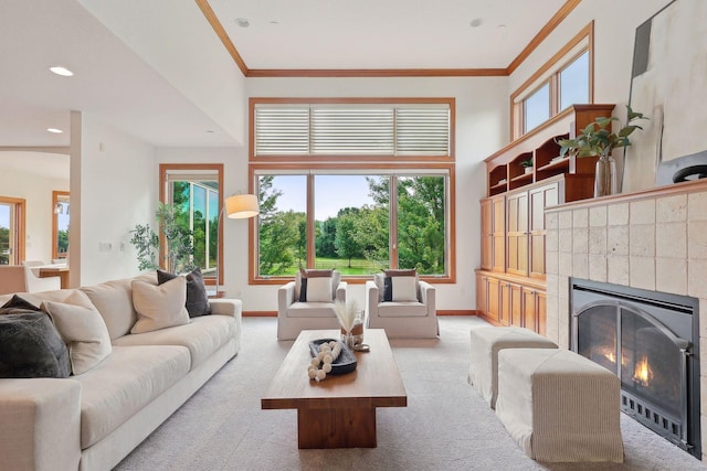 living room featuring a tiled fireplace, plenty of natural light, and light carpet