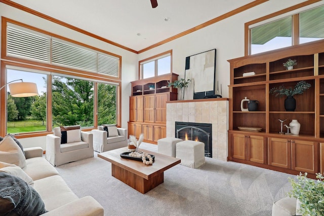 living room with crown molding, light colored carpet, a fireplace, and a high ceiling