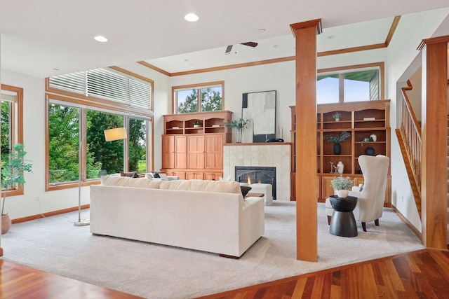 living room featuring crown molding, a fireplace, and light wood-type flooring