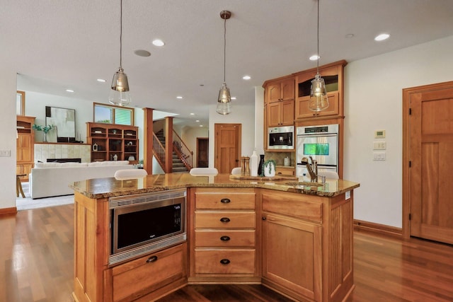 kitchen with pendant lighting, stainless steel appliances, a center island, and sink