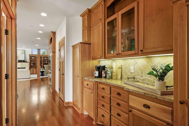 kitchen with tasteful backsplash, dark hardwood / wood-style floors, and light stone countertops