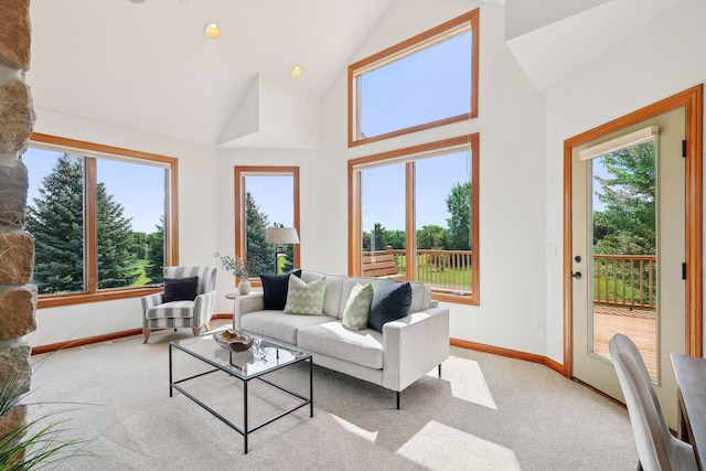 living room with light carpet and high vaulted ceiling