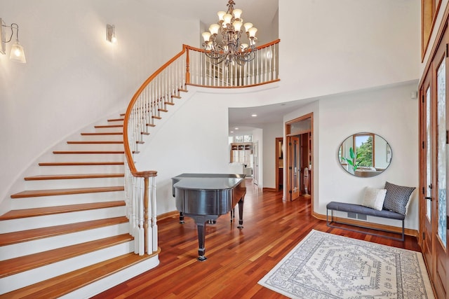 entrance foyer featuring a high ceiling, hardwood / wood-style floors, and a notable chandelier