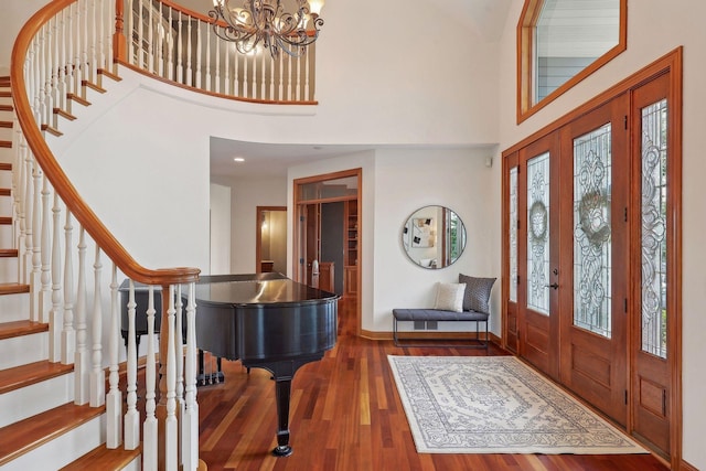 entrance foyer featuring dark hardwood / wood-style flooring, a notable chandelier, and a high ceiling