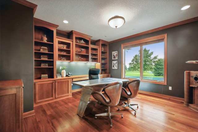 office space featuring hardwood / wood-style floors, ornamental molding, and a textured ceiling