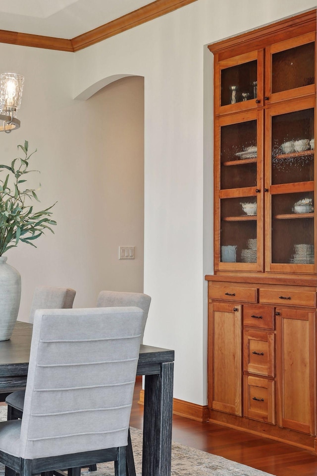 dining area with crown molding and dark hardwood / wood-style floors