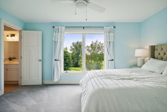 carpeted bedroom featuring multiple windows, ceiling fan, and ensuite bath