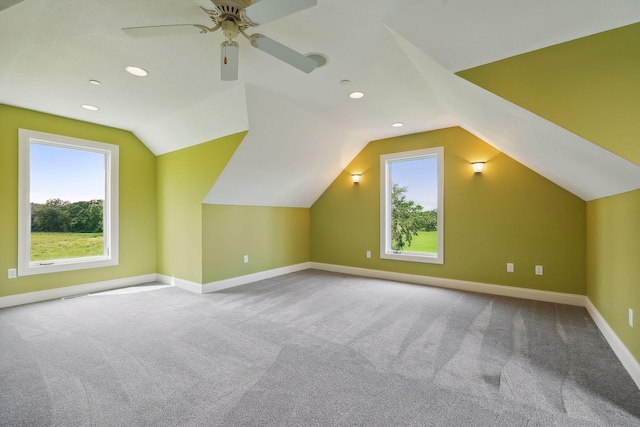 bonus room featuring ceiling fan, lofted ceiling, a healthy amount of sunlight, and carpet