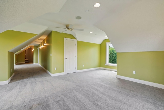 bonus room featuring vaulted ceiling, light carpet, ceiling fan, and a textured ceiling