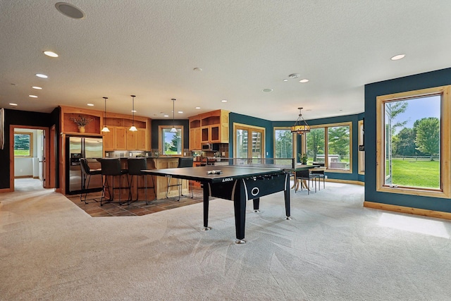 game room featuring light colored carpet and a textured ceiling